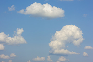 Blue sky with puffy white clouds in bright clear sunny day