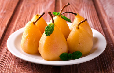 Poached pears with mint on white plate