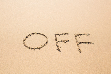 off - inscription on sand beach.