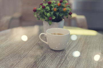 cup of hot latte coffee and bouquet of fake red fruit, vintage t