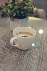 cup of hot latte coffee and bouquet of fake red fruit, vintage t