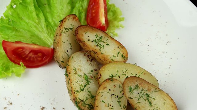 Roasted potatoes with leaf of salad, dill and tomato
