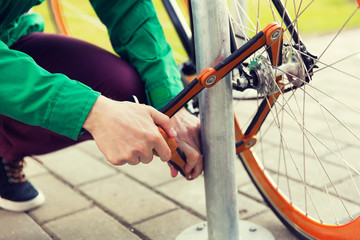 close up of man fastening bicycle lock on parking