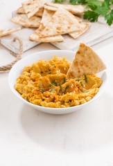 traditional sauce hummus with pita bread on white table