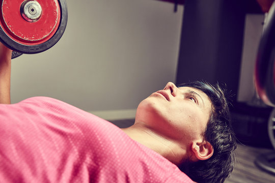 Ragazza solleva pesi in palestra