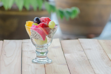 mixed fruit in glass on wood table, healthy food