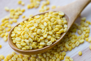Yellow millet on wooden spoon