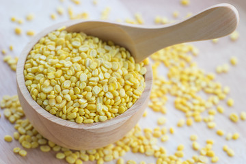 Yellow millet grains in wooden bowl