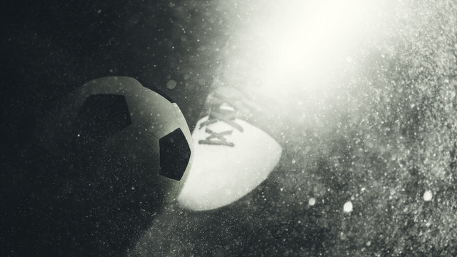 Beam of light illuminating a soccer boot and ball
