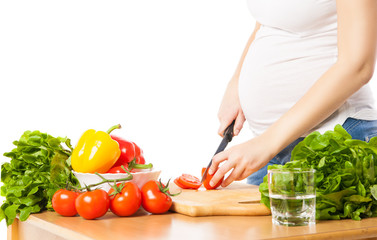 Close-up of pregnant woman cutting tomato