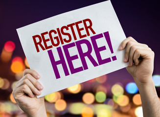 Register Here placard with bokeh background