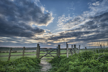 Fototapeta premium Beautiful English countryside landscape over fields at sunset