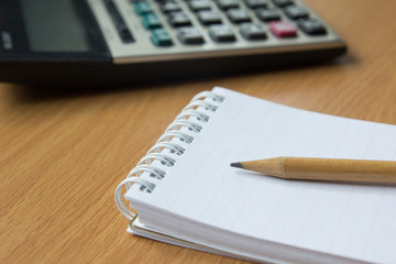 Calculator, notebook and pencil