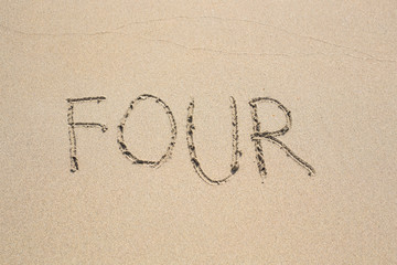 The number four drawn on sand at the beach, holiday concept background.