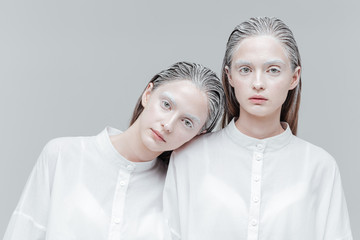 Close-up portrait of two women in smart white shirts