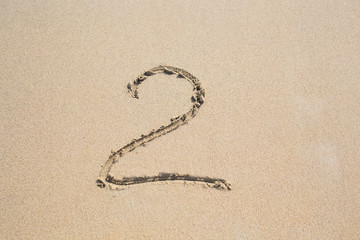 Two written in the sand at a beach