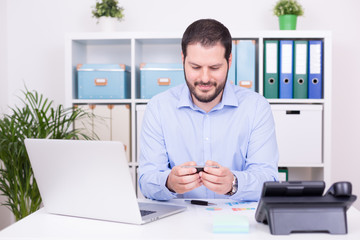 Geschäftsmann im Büro tippt SMS in Smartphone © TeamDF