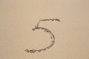 Number five. Sand Alphabet: digits. Concept holiday background.