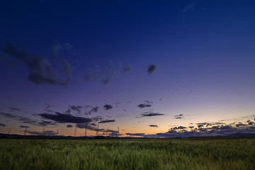 harvested field under burning clouds