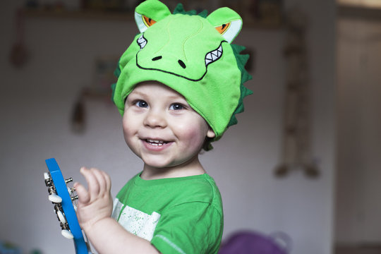 Smiling boy wearing dino hat
