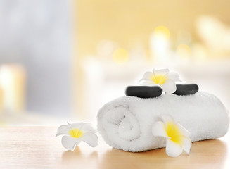 Spa stones with towel and plumeria, on blurred background