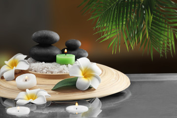 Fototapeta na wymiar Composition with spa stones and plumeria on blurred background