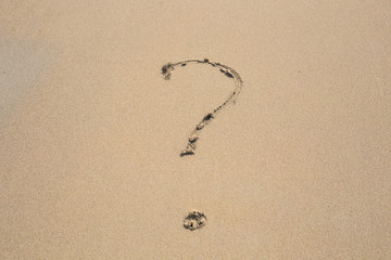 Fototapeta na wymiar question mark drawn on the sand of a beach
