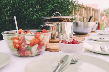 Grill on a table surrounded by plates with meal