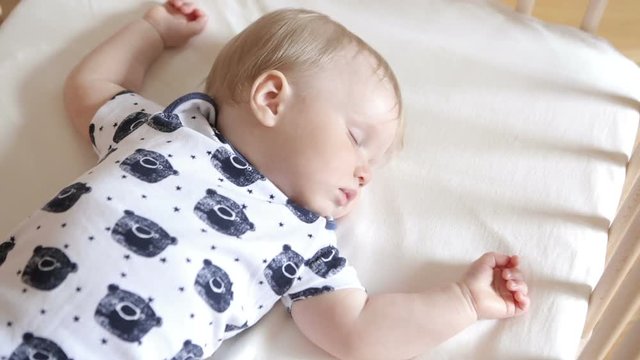 Peaceful adorable baby sleeping on his bed in a room. Soft focus. Sleeping baby concept. year-old babyboy sleeps at home