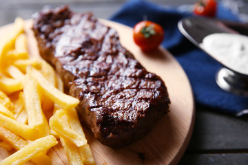 Grilled steak with french fries, salt and cherry tomatoes, closeup