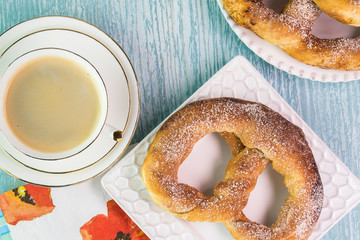 Fresh baked soft cinnamon flavored pretzels and cup of coffee.
