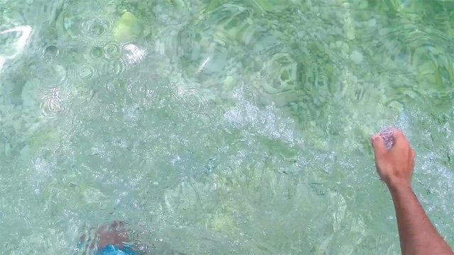 Young man enter in blue bay water on clean Croatian shore