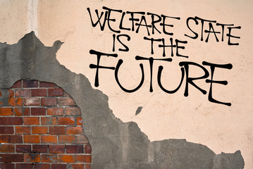 Handwritten graffiti Welfare State Is The Future sprayed on wall, anarchist aesthetics. Appeal to...