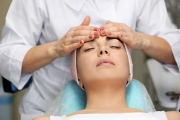 Young woman having face massage in a beauty salon