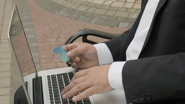 Businessman using his laptop to purchase something online with his credit card