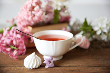 Cup of tea and flowers on wooden table