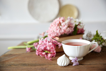 Obraz na płótnie Canvas Cup of tea and flowers on wooden table