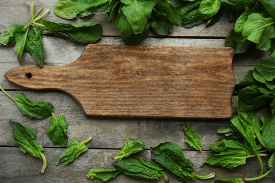 Fresh spinach leaves with cutting board