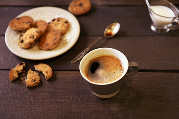 Cup of coffee with cookies on wooden table