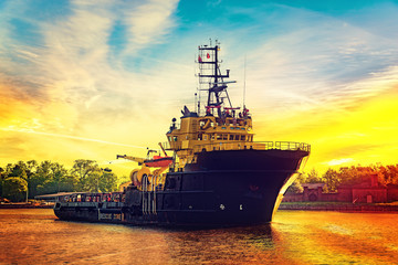 Obraz premium Tug boat at sunrise coming to port.