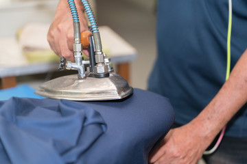 Close-up Of Maid Ironing Clothes On Ironing Board