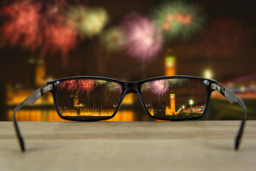 Big Ben at night in London, UK. Selective focused in glasses lenses. Vision concept