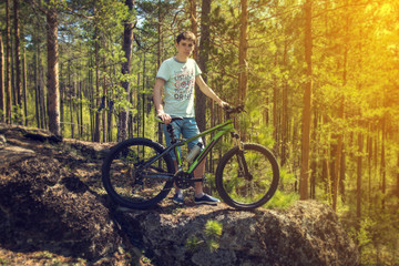 Fototapeta na wymiar biker with bike on the rocks. Sport, adventure, motivation.