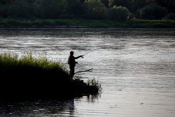 Fototapeta na wymiar Fisherman fishing on river , angler at sunset 