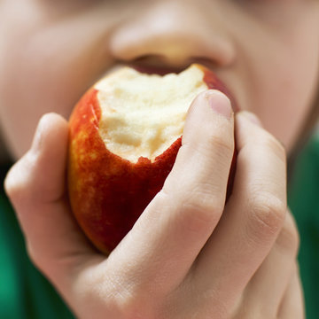 Boy eating apple, close-up