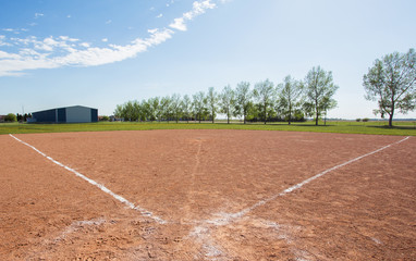 An empty baseball diamond in rural landscape in the afternoon