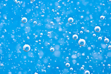 Close-up bubbles under water on blue background. Macro.
