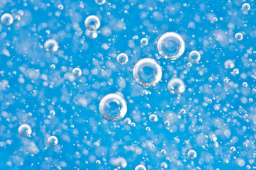 Bright bubbles, motion under water on blue background.