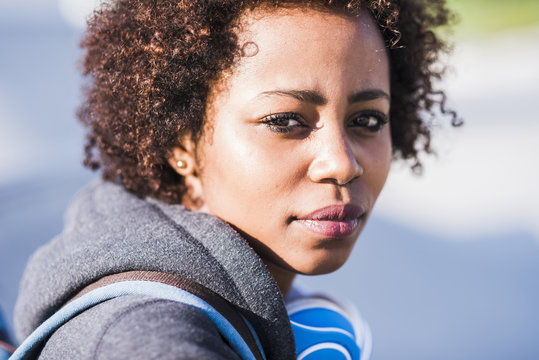 Portrait of young woman wearing headphones outdoors