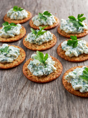 Bisquit cracker appetizers with cottage chees and parsley topping